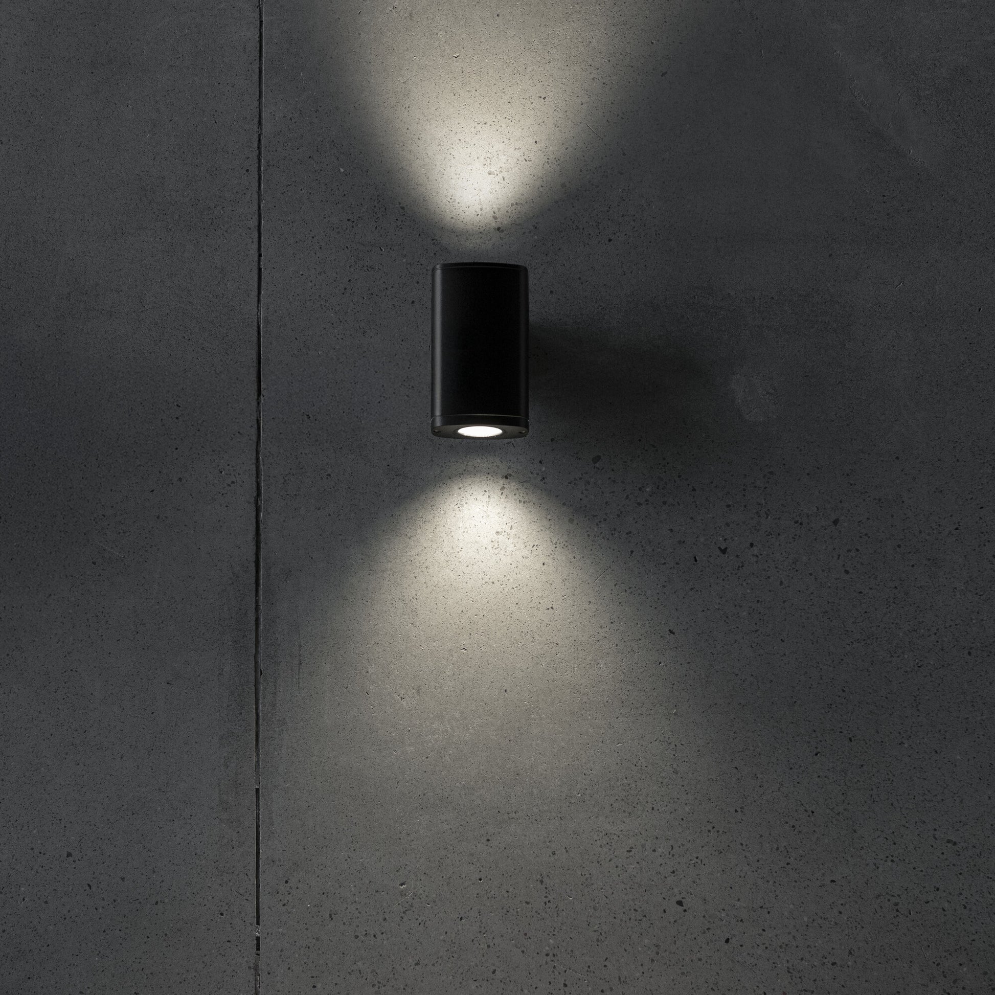 Twin GU10 facade wall light illuminated on a wall