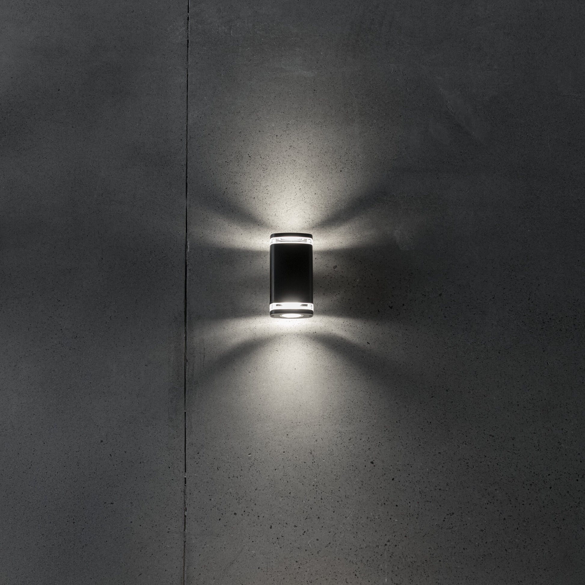 Wide twin GU10 facade wall light illuminated on a wall